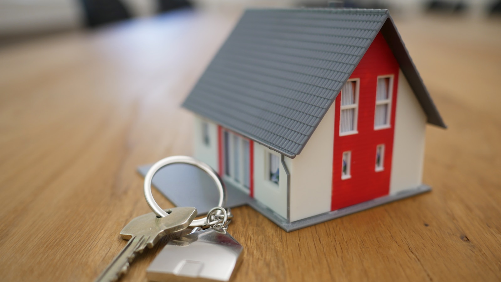 House keys on a contract with a calculator and notebook on a desk