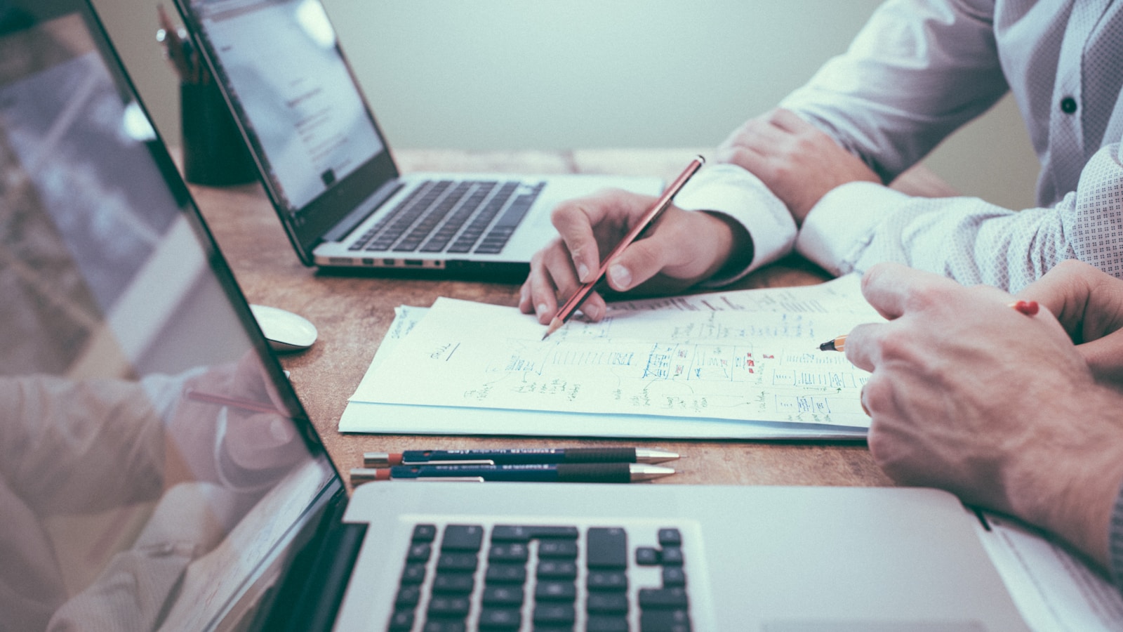 Founder writing a business plan with charts and notes spread on a desk