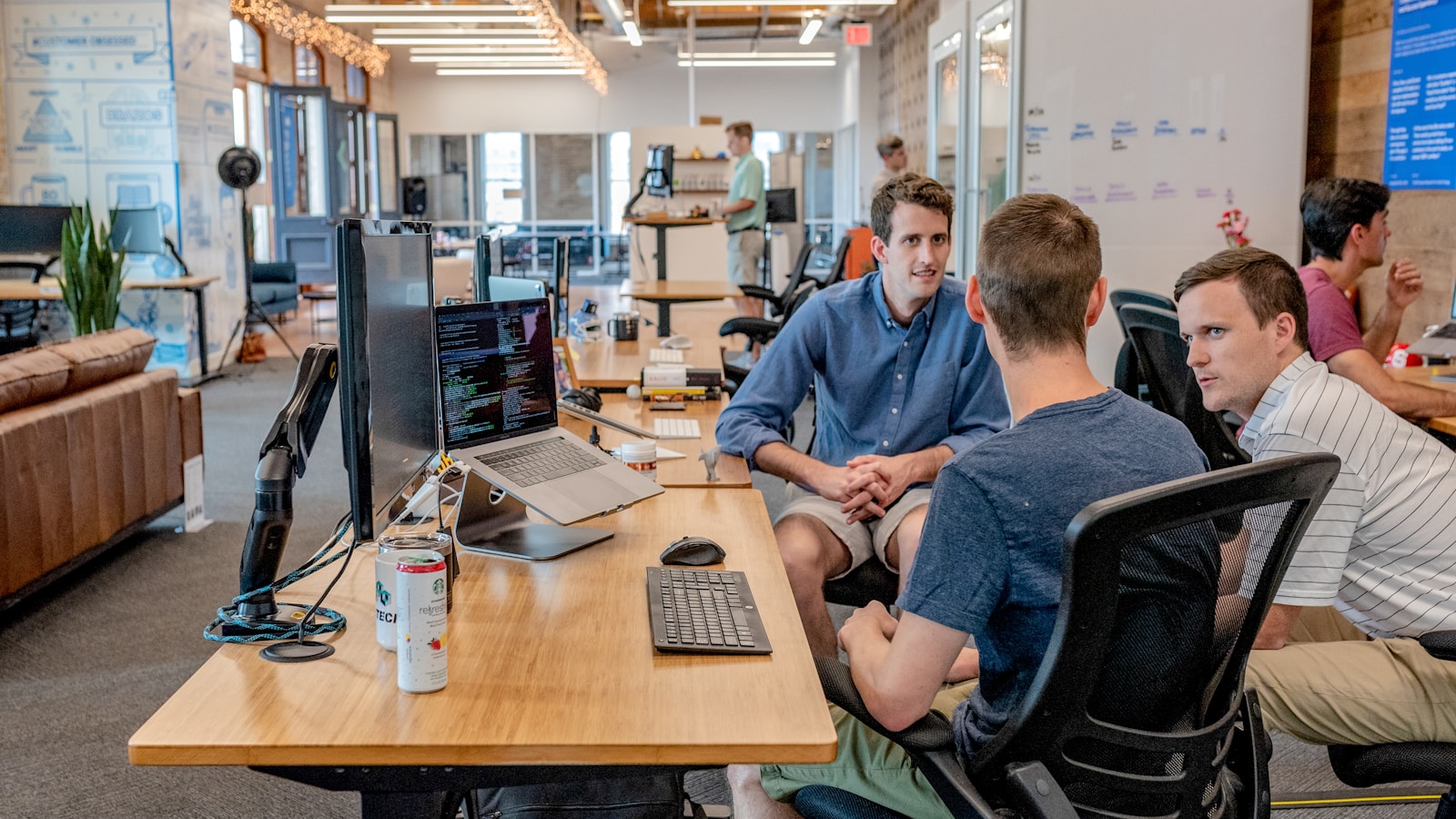 Diverse professional team collaborating around a laptop in a modern office